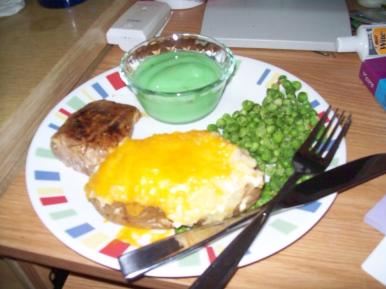 Plate of pork, potato, peas, and pistachio pudding