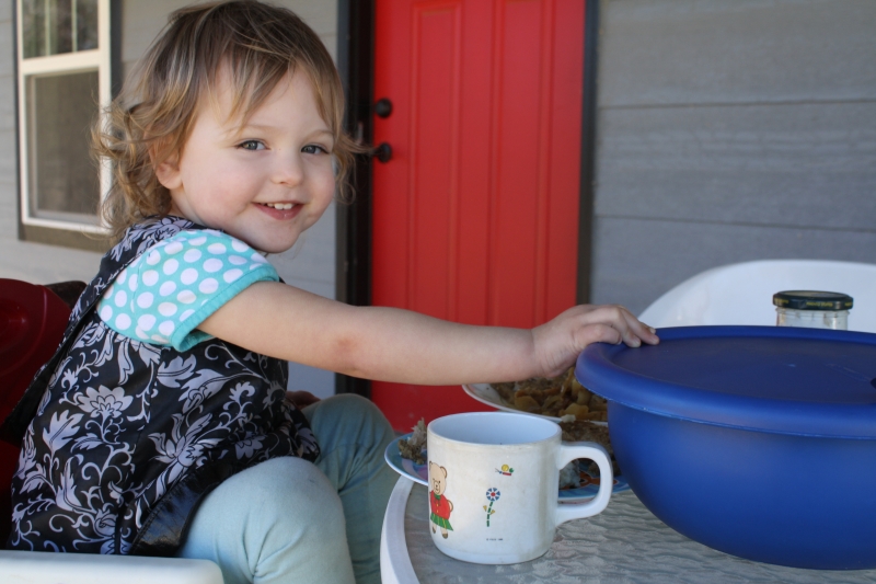 Tirzah Mae prepares for lunch at the porch table