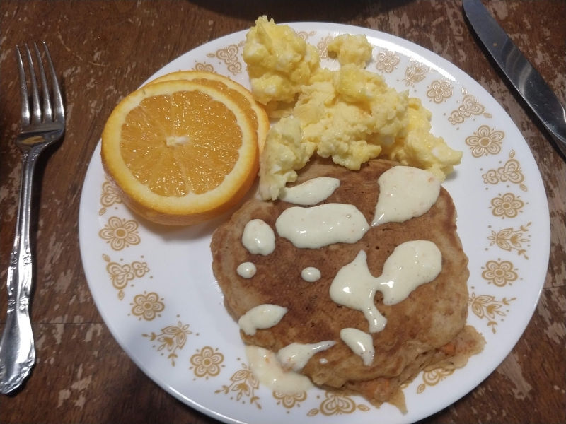 Carrot cake pancakes with orange glaze, scrambled eggs, and grapefruit