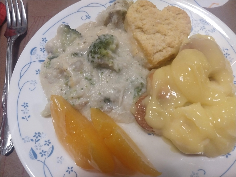 Chicken and broccoli gravy with biscuits, banana pudding, and canned peaches